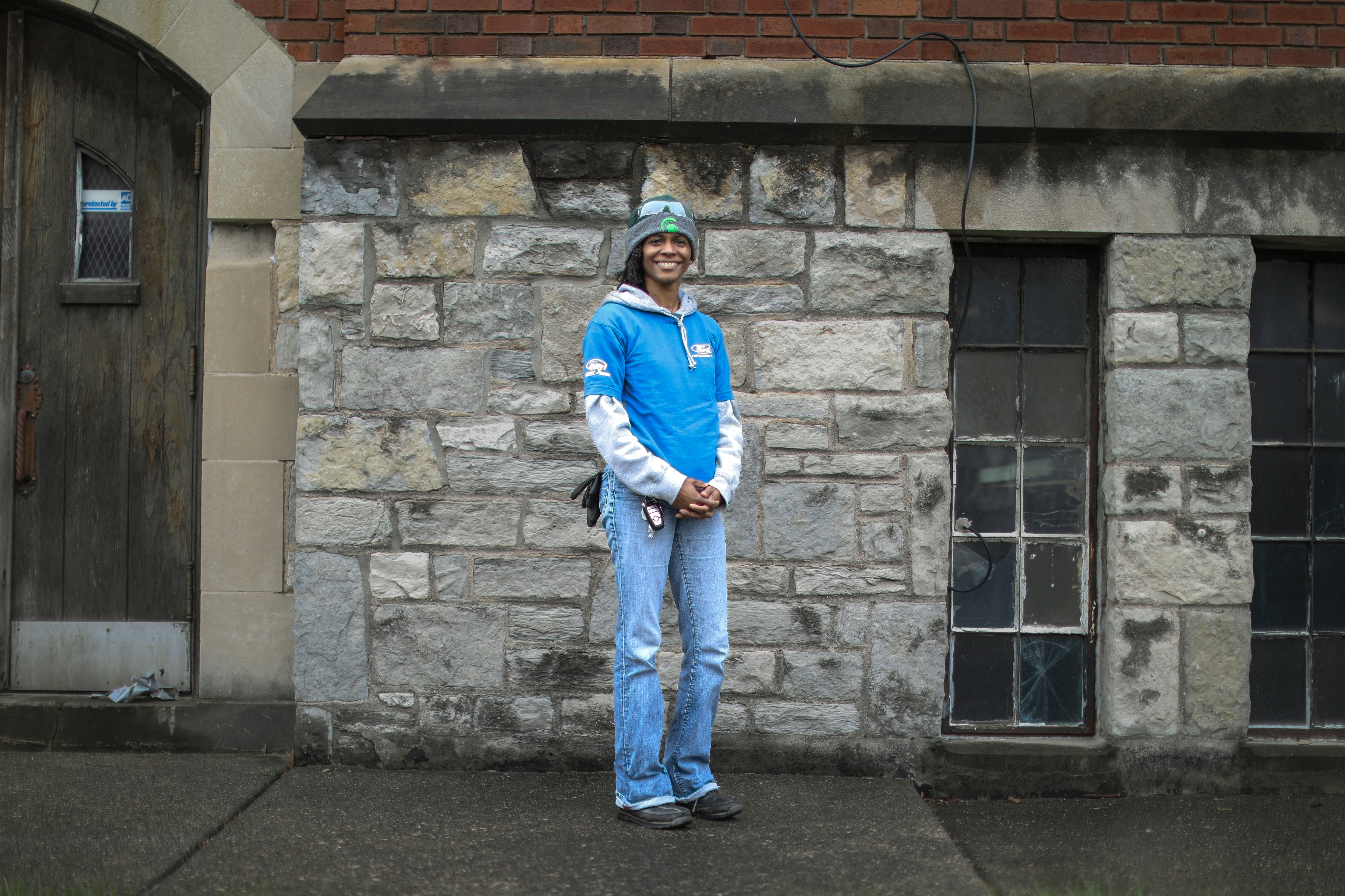 A woman in work gear poses for a photo.